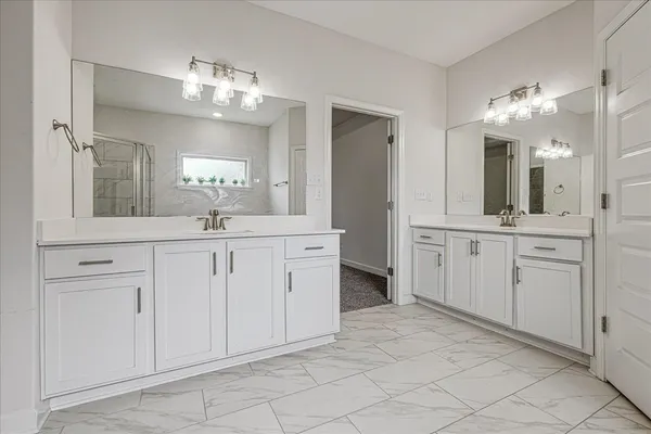 a spacious bathroom with a double vanity sink and a mirror