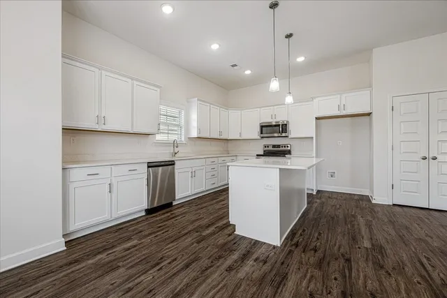 a kitchen with granite countertop white cabinets and white appliances