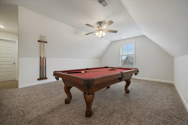 a room with pool table and a ceiling fan