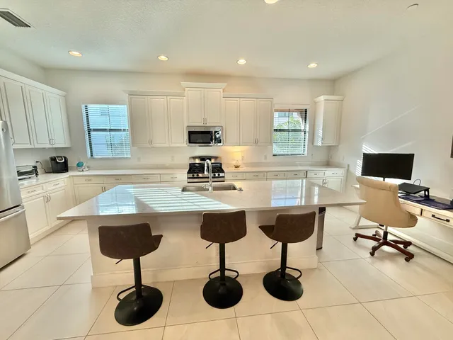 a kitchen with a sink dining table and chairs