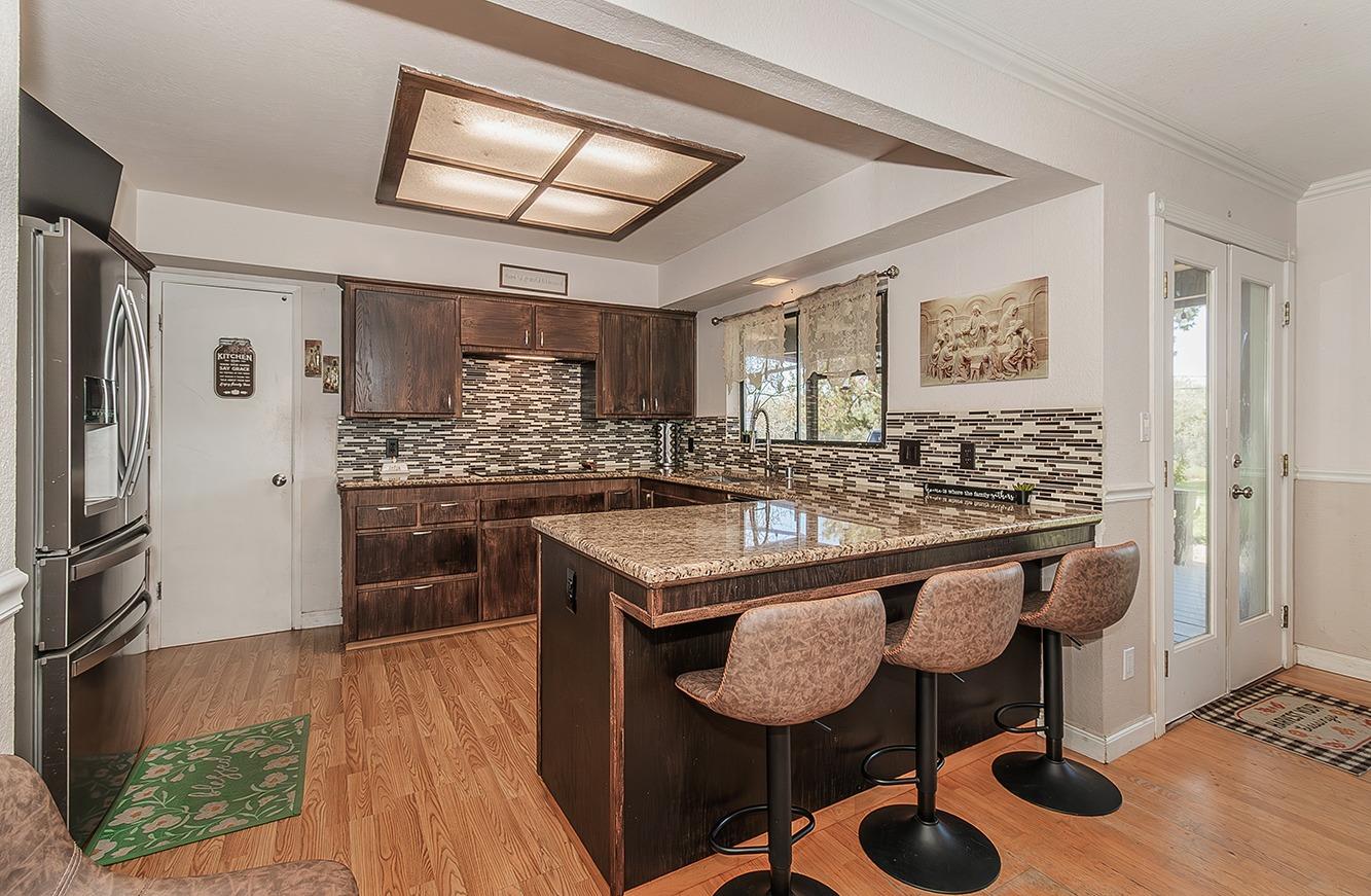 41371 Butte Way Madera, CA 93636 - Photo 14 of 84 a kitchen with stainless steel appliances granite countertop a sink and a refrigerator