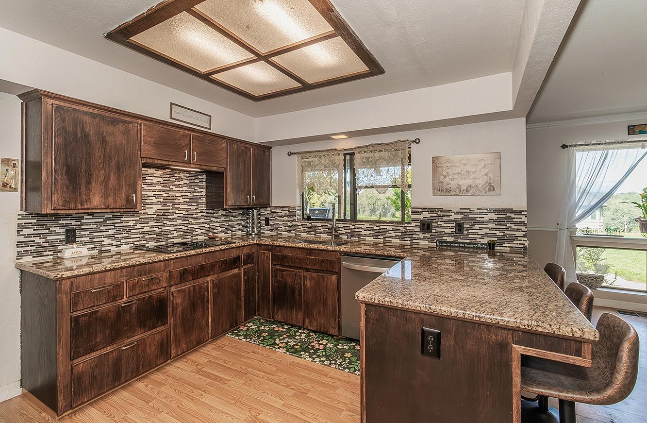 41371 Butte Way Madera, CA 93636 - Photo 15 of 84 a kitchen with stainless steel appliances granite countertop a sink stove and cabinets