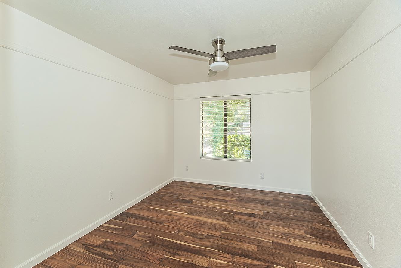 41371 Butte Way Madera, CA 93636 - Photo 25 of 84 an empty room with wooden floor ceiling fan and windows