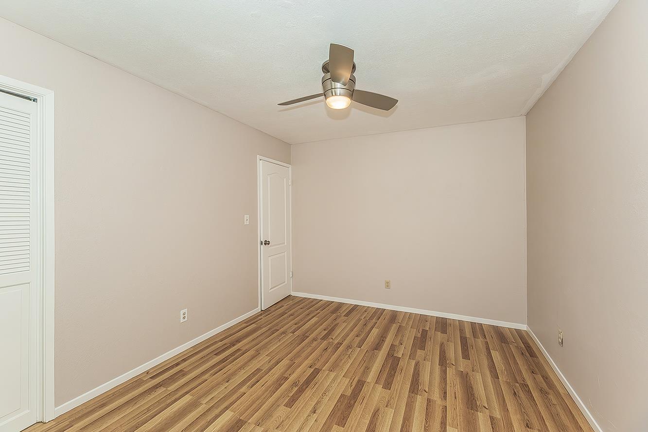 41371 Butte Way Madera, CA 93636 - Photo 33 of 84 an empty room with wooden floor ceiling fan and window