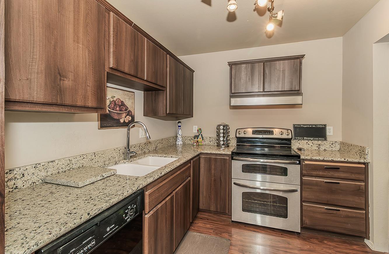 41371 Butte Way Madera, CA 93636 - Photo 51 of 84 a kitchen with granite countertop a sink stainless steel appliances and cabinets
