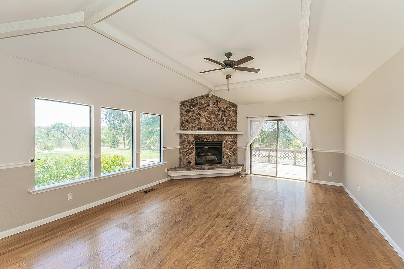 41371 Butte Way Madera, CA 93636 - Photo 7 of 84 a view of an empty room with a window and wooden floor