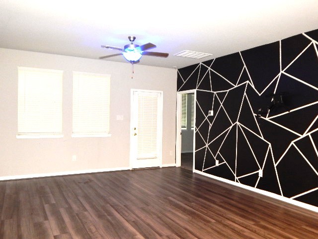 7103 Silverleaf Oak Street Conroe, TX 77304 - Photo 5 of 20 an empty room with wooden floor and windows