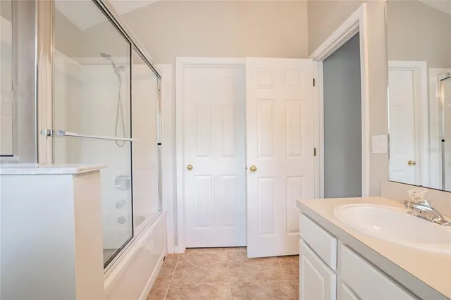 a bathroom with a granite countertop sink a mirror and a bathtub
