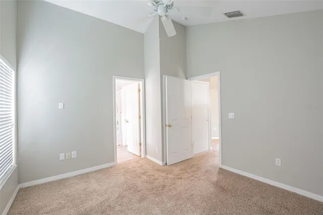an empty room with a ceiling fan and a window