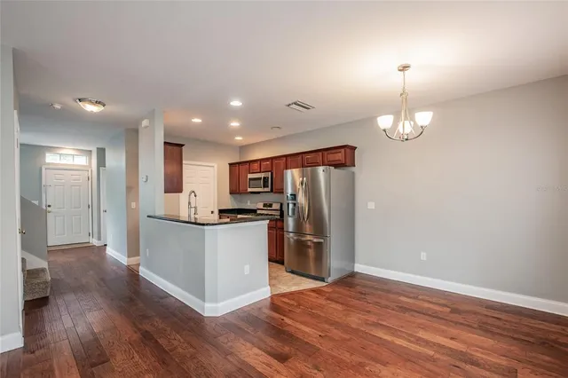 a kitchen with stainless steel appliances granite countertop a refrigerator and a stove top oven