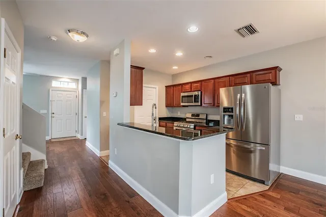 a kitchen with stainless steel appliances a refrigerator and a stove top oven