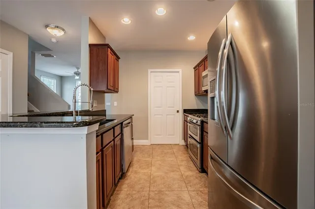 a kitchen with stainless steel appliances granite countertop a refrigerator and a sink