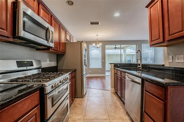a kitchen with stainless steel appliances granite countertop a stove and a microwave