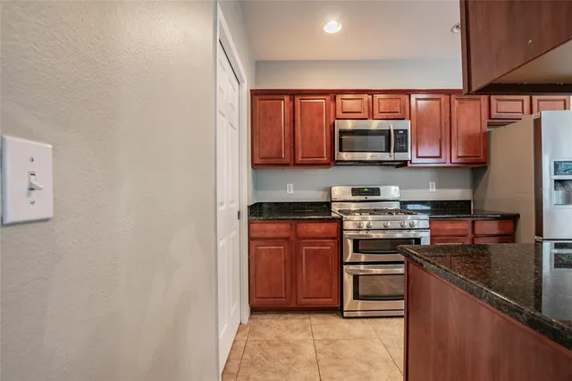 a kitchen with stainless steel appliances granite countertop a stove top oven a sink and a microwave