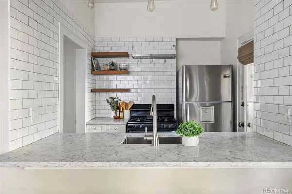 a bathroom with a granite countertop sink a potted plant and a shower