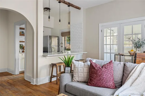 a living room with furniture floor to ceiling window and wooden floor