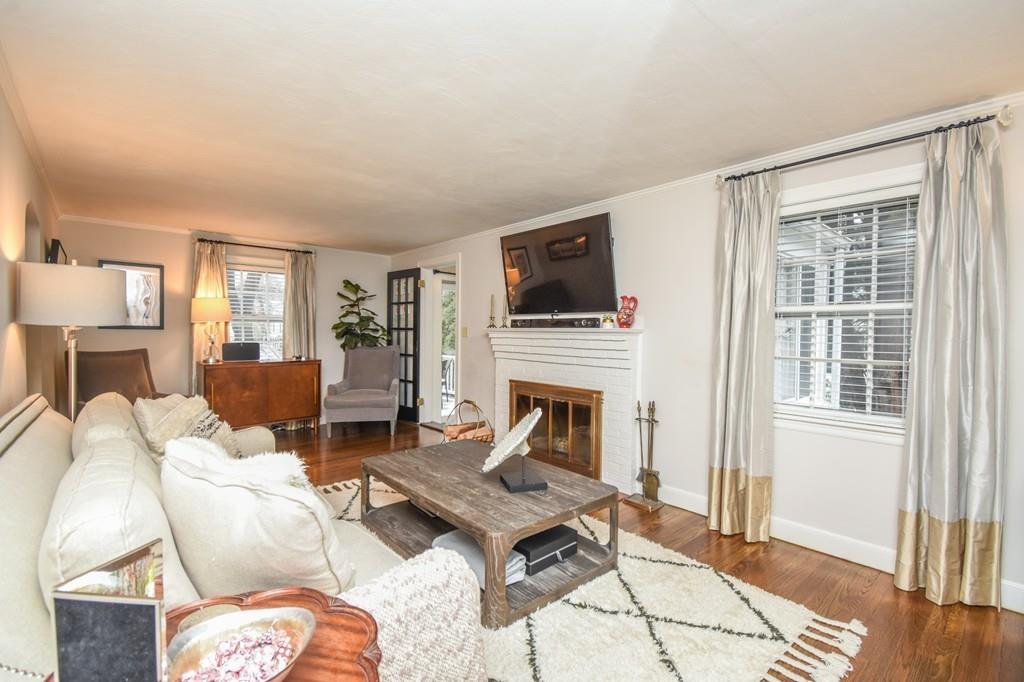 21 Lancaster Road Needham, MA 02492 - Photo 11 of 35 a living room with furniture a flat screen tv and a fireplace
