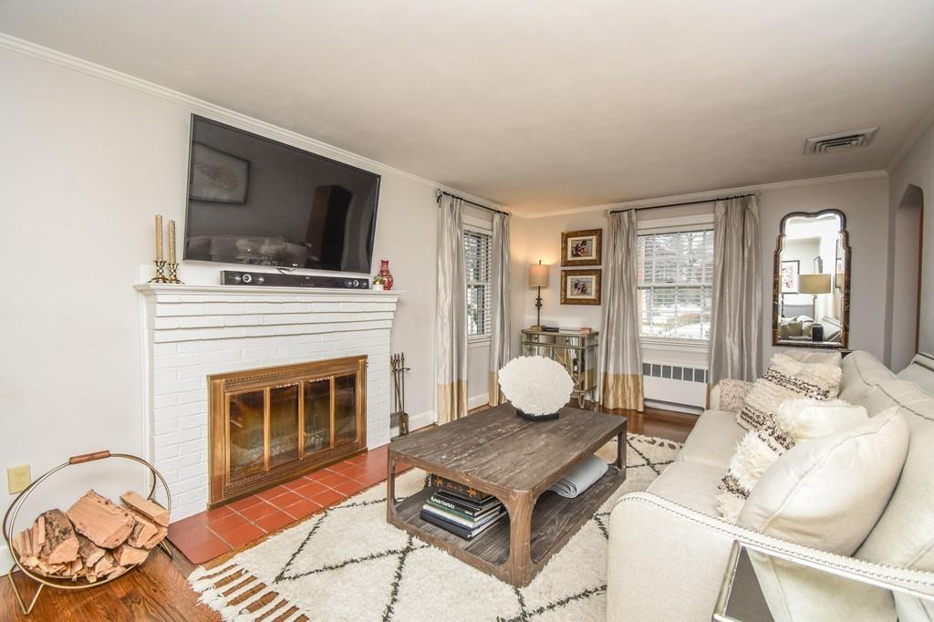 21 Lancaster Road Needham, MA 02492 - Photo 13 of 35 a living room with furniture a flat screen tv and a fireplace