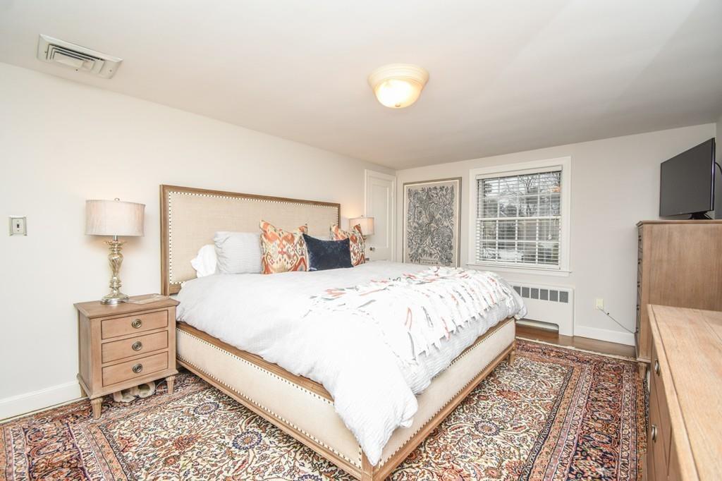 21 Lancaster Road Needham, MA 02492 - Photo 19 of 35 a bedroom with a bed and wooden floor