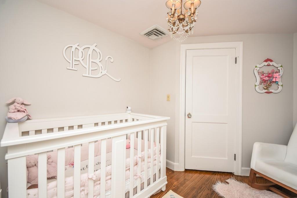 21 Lancaster Road Needham, MA 02492 - Photo 26 of 35 a bedroom with a bed and a chandelier