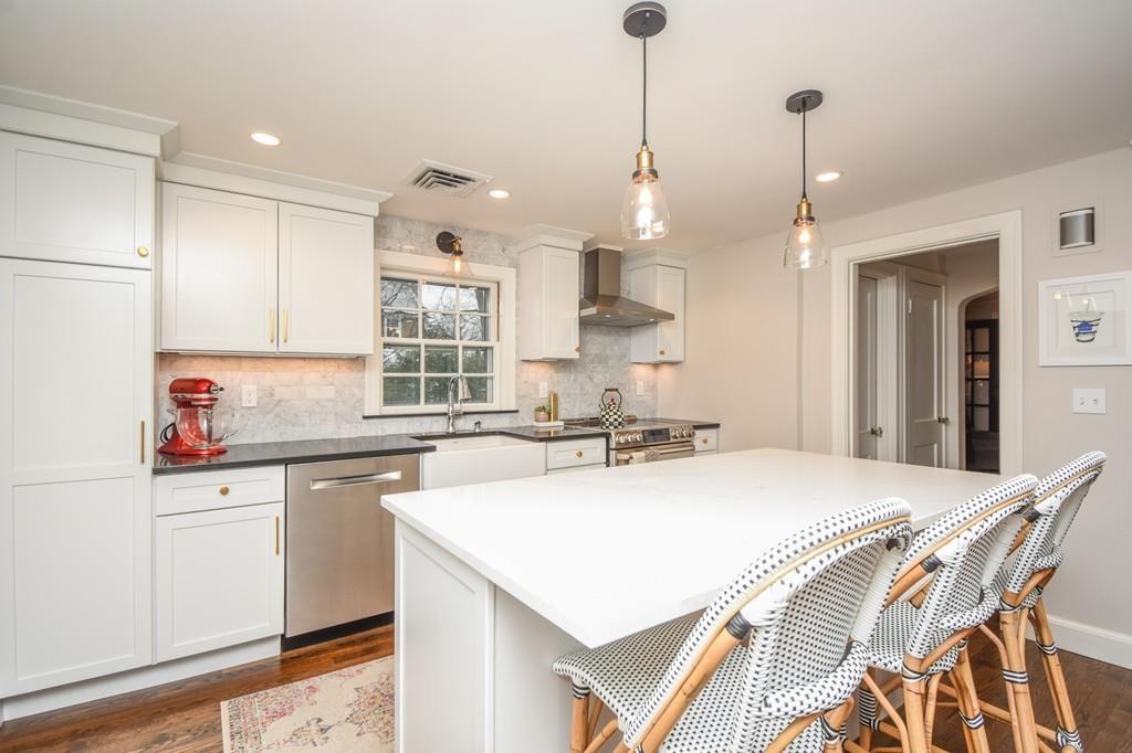 21 Lancaster Road Needham, MA 02492 - Photo 5 of 35 a kitchen with a stove a sink a center island and cabinets