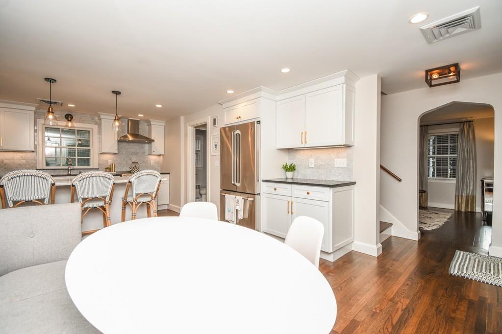 21 Lancaster Road Needham, MA 02492 - Photo 9 of 35 a kitchen with stainless steel appliances kitchen island granite countertop a refrigerator a stove top oven and white cabinets
