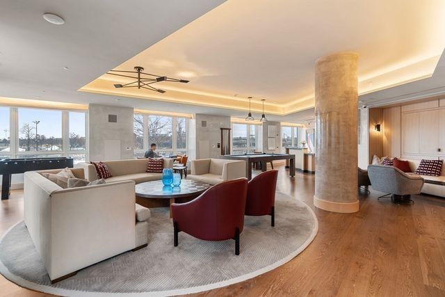 a living room with fireplace furniture and a large window