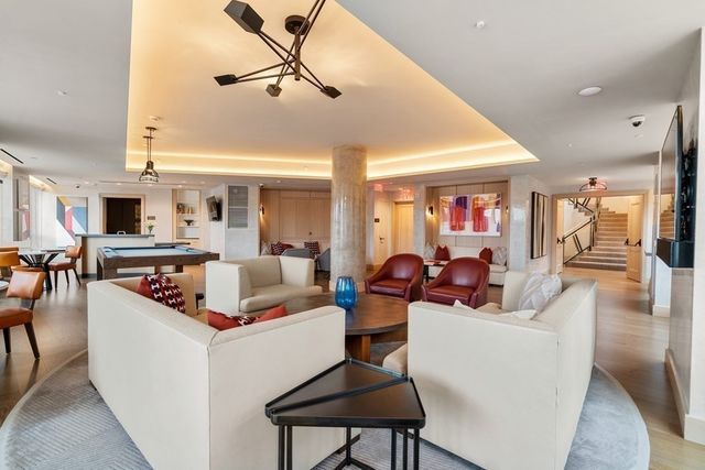 a living room with furniture kitchen view and a chandelier