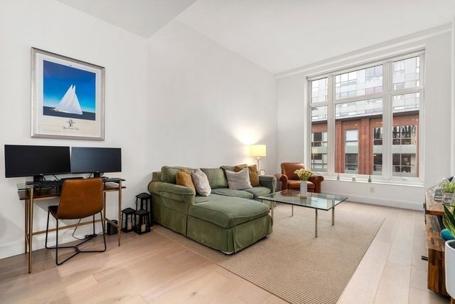 a living room with furniture a fireplace and a large window