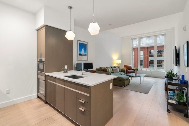 a kitchen with a stove a refrigerator a dining table and chairs with wooden floor