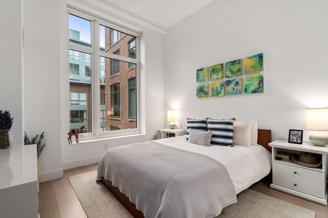 a bedroom with a bed and a large window