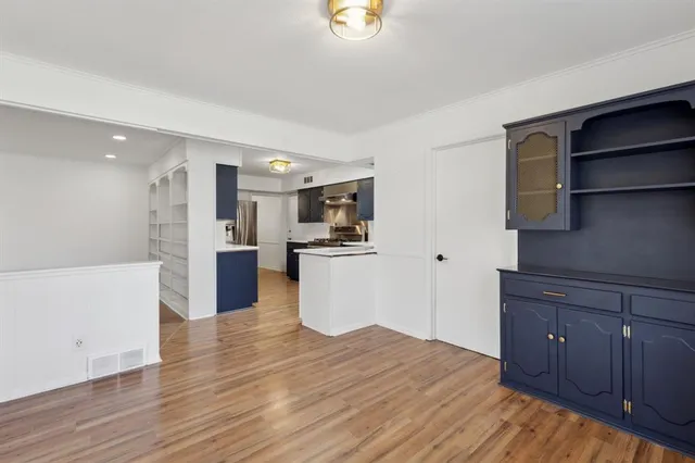 a kitchen with stainless steel appliances kitchen island wooden floors and wooden cabinets