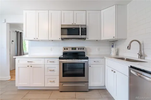 a kitchen with stainless steel appliances granite countertop a refrigerator stove a sink and microwave