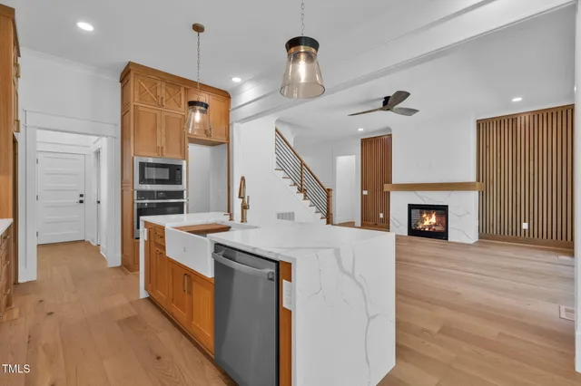 a view of an empty room with wooden floor fireplace and a window
