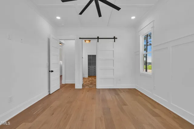 an empty room with windows and fan