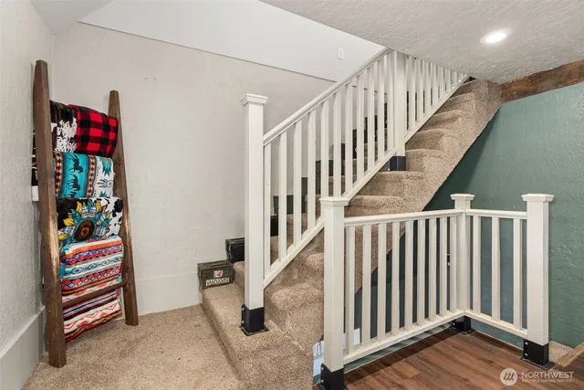 a view of entryway with stairs and paintings on the wall