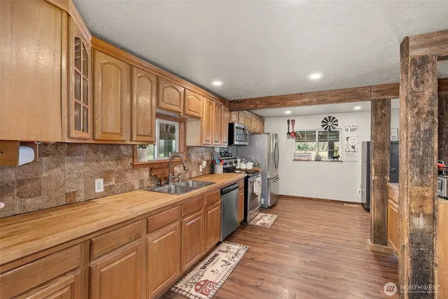 a kitchen with stainless steel appliances granite countertop a lot of counter space and wooden floors