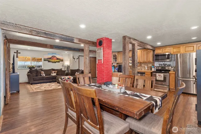 a kitchen with stainless steel appliances granite countertop a refrigerator dining table and chairs