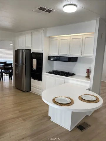 a kitchen with a refrigerator a stove a sink and a dining table