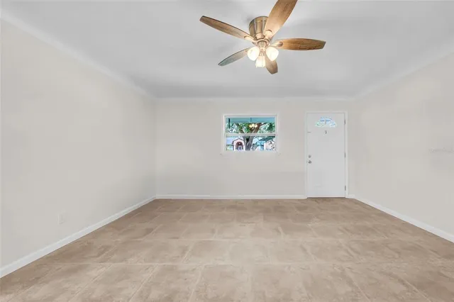an empty room with a window and a ceiling fan