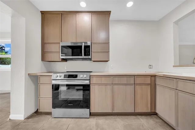 a kitchen with granite countertop a stove and a microwave