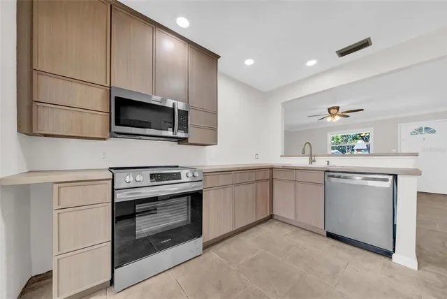 a kitchen with granite countertop cabinets stainless steel appliances and a counter space
