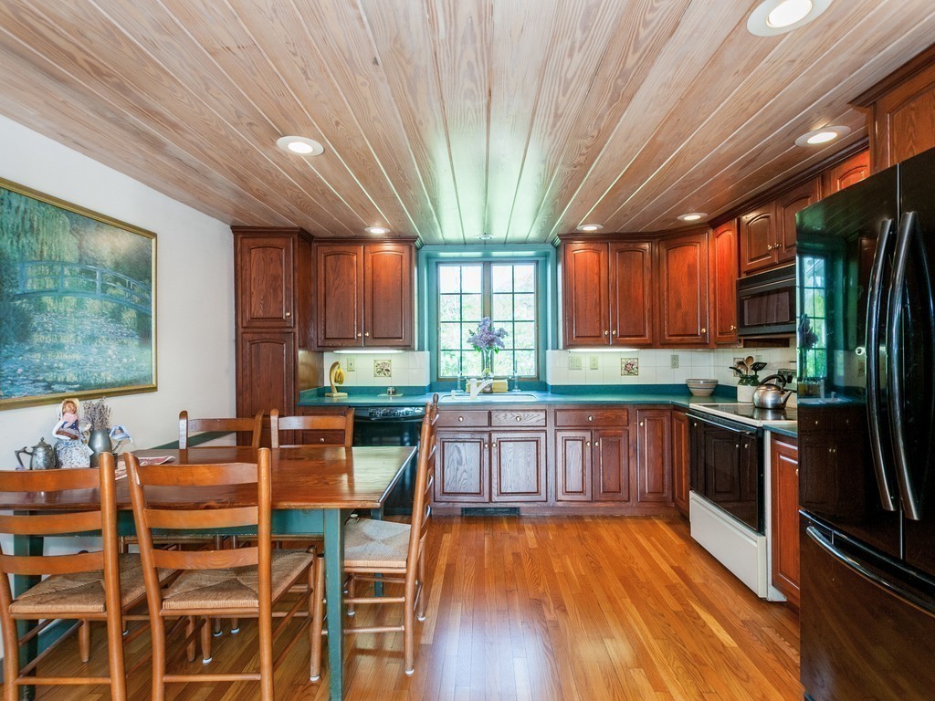 17 Clinton Street Hopkinton, MA 01748 - Photo 8 of 27 a kitchen with stainless steel appliances wooden floors wooden cabinets dining table and chair