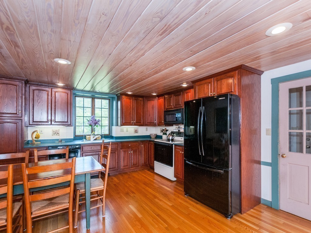 17 Clinton Street Hopkinton, MA 01748 - Photo 9 of 27 a kitchen with stainless steel appliances kitchen island granite countertop a refrigerator and wooden cabinets
