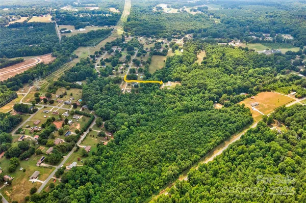 an aerial view of residential houses with outdoor space and trees