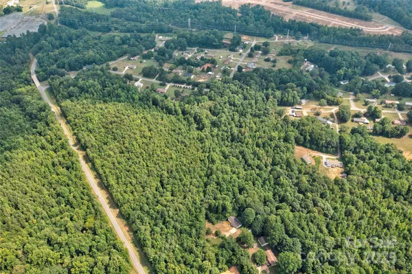 an aerial view of residential houses with outdoor space and trees