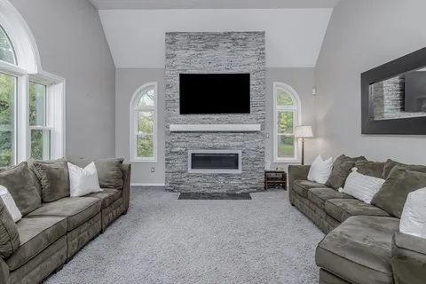 a living room with furniture a flat screen tv and a fireplace