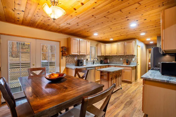a view of a dining room with furniture a kitchen and chandelier