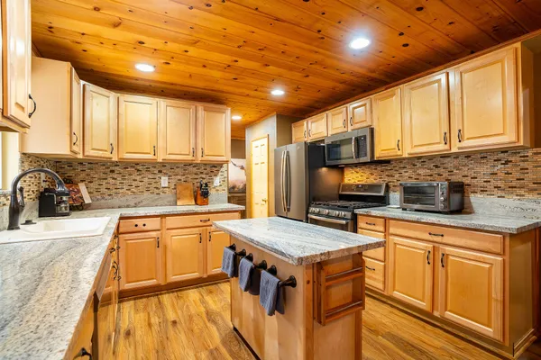 a kitchen with stainless steel appliances granite countertop a sink stove and cabinets