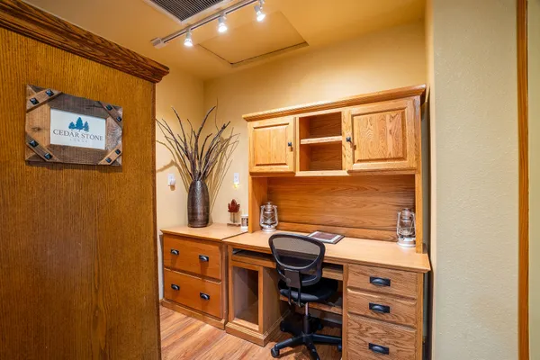 a view of a workspace with furniture and a window
